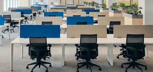 Modern open-plan office space featuring clean workstations, ergonomic chairs, and sanitized carpets provided by professional office cleaning services in Jacksonville, FL.